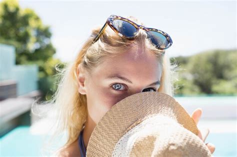 Premium Photo Beautiful Blonde Hiding Face With Hat Poolside