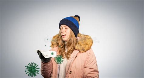 Young Woman In Winter Clothes Is Holding A Handkerchief And Sneeze