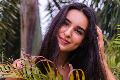 Portrait Of Fit Tanned Slim Perfect Body Woman In Green Tiny Bikini Posing With Tropical Leaves