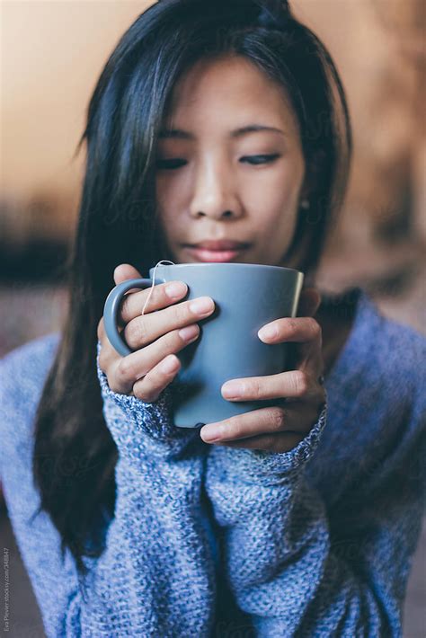 Woman Holding A Cup Of Tea Between Her Hands By Eva Plevier