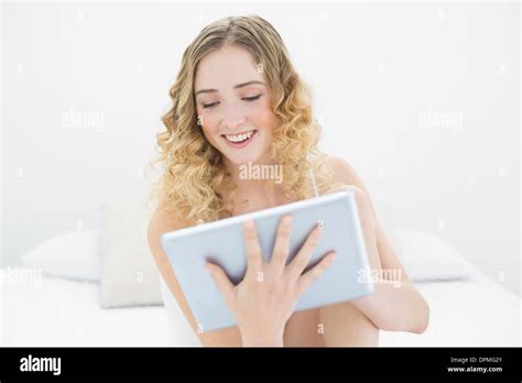 Pretty Smiling Blonde Sitting On Bed Using Tablet Stock Photo Alamy