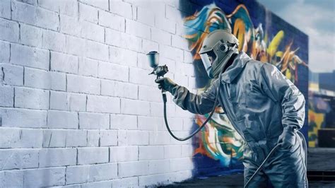 Premium Photo | Worker painting wall with spray gun in white color