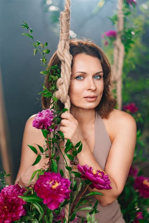 A Beautiful Brunette Woman On A Swing With Peony Flowers Stock Image Image Of Modern Sexual
