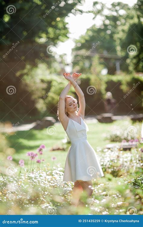 Mooie Blonde Jarige Jongen Met Krullend Haar In Een Witte Jurk In De Zonnige Zonnestralen In
