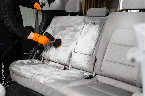 Smearing detergent on car textile seats using drill with brush for dry ...