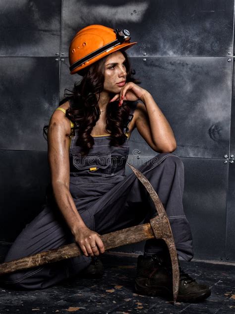 Female Miner Worker With Pickaxe In Coveralls Over His Naked Body Sitting On The Floor On