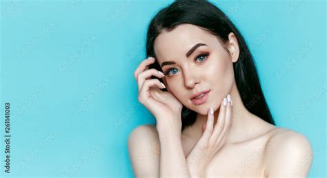 Portrait Of Model With Natural Nude Make Up With Bare Shoulders On Blue Background Beautiful