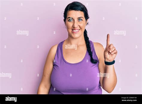 Plus Size Brunette Woman Wearing Sportswear Smiling With An Idea Or Question Pointing Finger Up