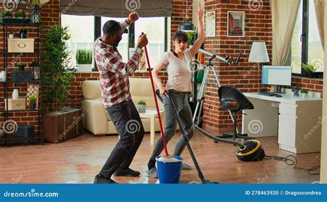 Happy Man And Woman Doing House Chores And Dancing Stock Photo Image