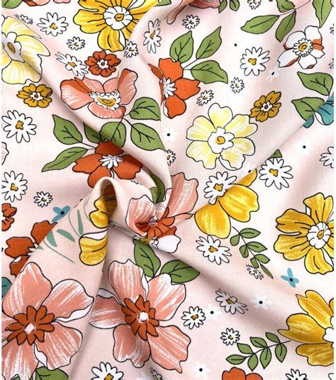 Tissu viscose rose nude imprimé de fleurs oranges et jaunes