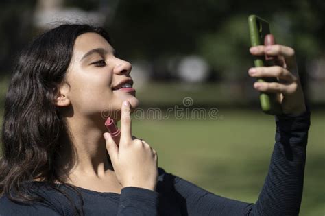Latina Teen In A Park Putting On Lipstick Stock Image Image Of Lipstick Park 305973975