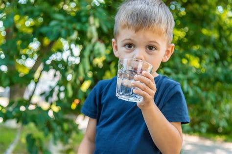 El Ni O Bebe Agua De Un Vaso Enfoque Selectivo Foto Premium