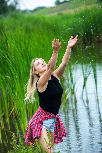 Das blonde Mädchen mit den langen Haaren amüsiert sich in der grünen und schönen Natur auf dem