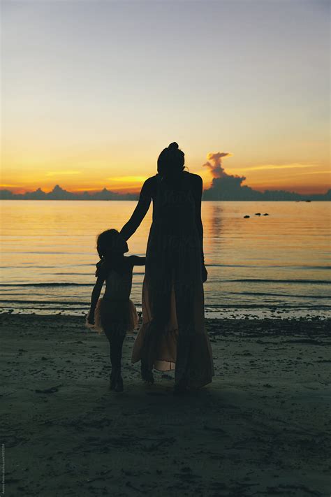 Daughter With Mom Enjoying The Sunset On The Beach Del Colaborador De