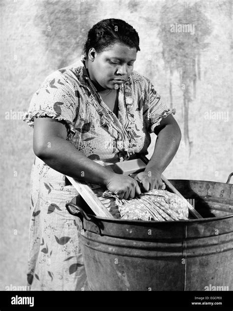 1930s African American Woman Washing Scrubbing Clothes On Washboard In