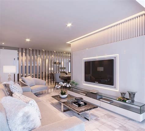 A Living Room Filled With White Furniture And A Flat Screen Tv Mounted