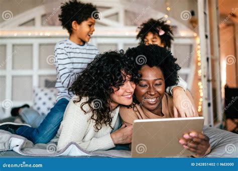 Feliz Pareja Gay Mirando Una Tableta Digital Y Divirtiéndose Con Los Niños Juntos En Casa Foto