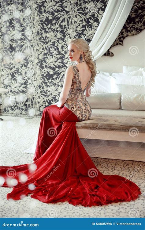 Port Modèle De Femme Blonde élégante Dans La Robe Rouge Luxueuse Avec Le Lon Photo stock Image