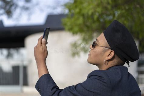 Latino Gay Male With Makeup On Wearing Trendy Hat Looking At Cell Phone Stock Image Image Of