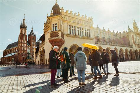 Krakow, Poland, 2023 - guide with tour group walk together in main
