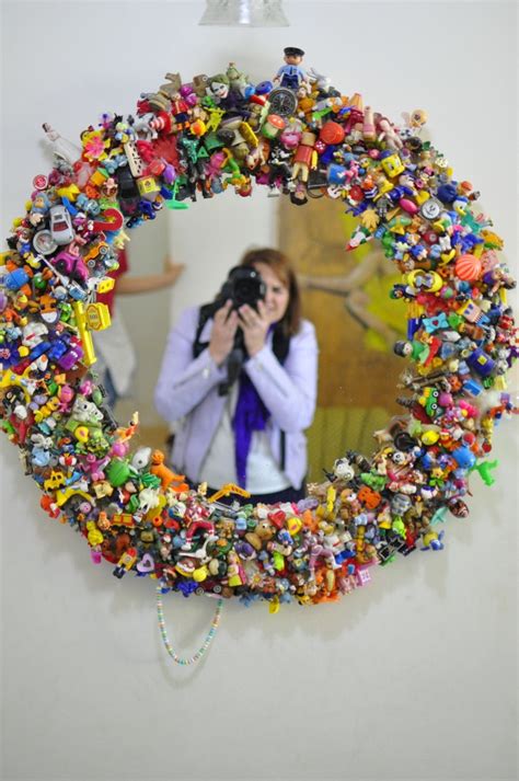 A Woman Taking A Photo In Front Of A Mirror Covered With Toy Figurines