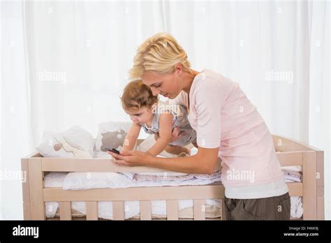 Happy Blonde Woman With His Son Using Pohne Stock Photo Alamy