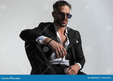 Attractive Bearded Man With Undone Bowtie Holding Knee Up Stock Image