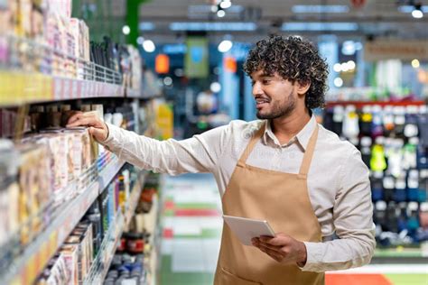 grocery store employee stocking shelves  working   tablet
