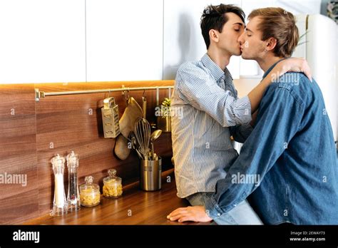 Caucasian Gay Couple Two Homosexual Guys Passionately Hug And Kiss At Home In The Kitchen One