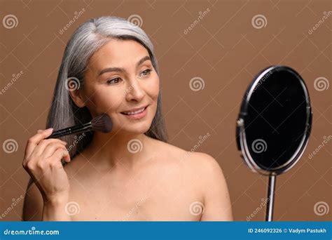 Adorable Middle Aged Blonde Woman Sitting On Bed And Talking On Mobile Phone Royalty Free Stock