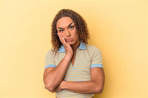 Joven transexual latina aislada de fondo amarillo que está aburrida fatigada y necesita un día