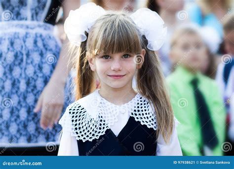 Portrait Of A Beautiful Little Girl In A School Dress And In Bows