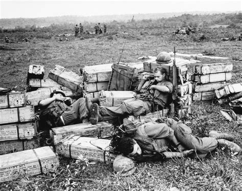 Three American Marines Sleep Atop Ammunition Boxes During A Pause In