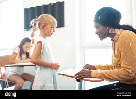 Beautiful Blonde Haired Pupil Coming To Teacher Stock Photo Alamy
