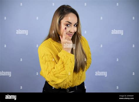 Jeune Belle Femme Blonde Avec De Longs Cheveux Portant Un Chandail Jaune Pointant Vers L Oeil