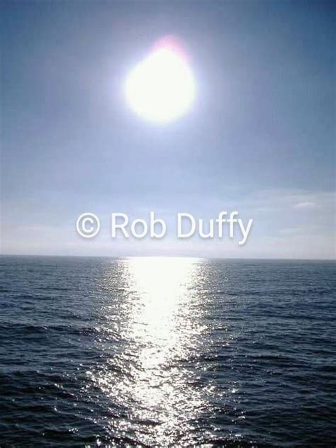 The Sun Shines Brightly Over The Ocean On A Clear Sunny Day With No Clouds