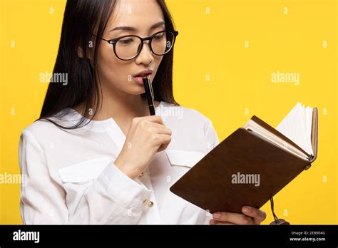 Pretty Brunette With Glasses Holding A Notebook In The Hands Of