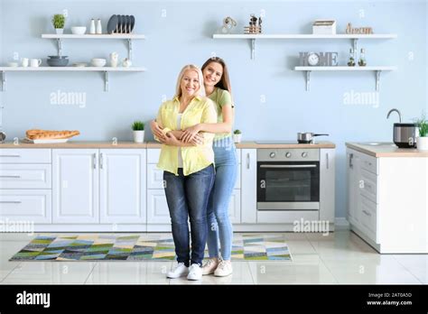 Mature Woman And Her Adult Daughter Together In Kitchen Stock Photo Alamy