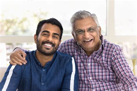 cheerful elderly indian father hugging young adult son stock photo