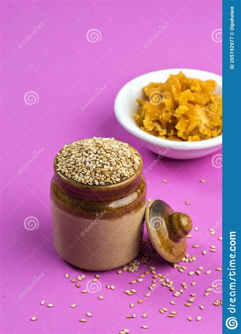 Sesame Seeds In Clay Pot With Jaggery In Bowl On Pink Background Stock