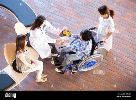 Doctor Giving Patient A Bunch Of Flowers As He Leaves Hospital Stock