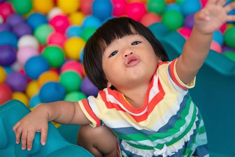 Happy Asian girl one and half years olds playing little colorful balls