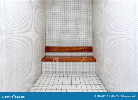 L Interno Molto Sobrio Di Una Cella Di Prigione Pareti Piastrellate Nude E Un Banco Di Legno