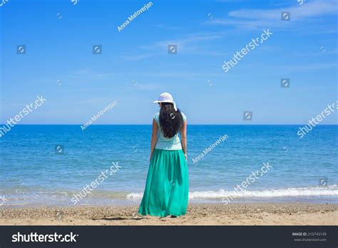 Brunette Female Standing Alone On Beach Stock Photo