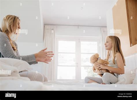 Foto de niña y mujer jugando con oso de peluche Madre e hija jugando