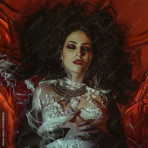 Vampire Halloween Woman Portrait Beauty Sexy Vampire Girl Lying In Red Satin Fabric Vampire