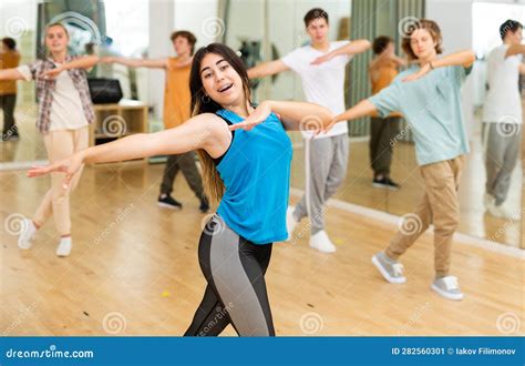 Happy Brunette Teenage Girl Practicing Vigorous Dance With Group Stock Image Image Of Indoors
