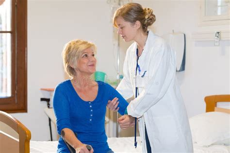 Enfermera Ayudando A La Anciana A Levantarse De La Cama Del Hospital