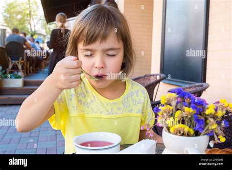 The Little Girl Has Breakfast In Cafe Stock Photo Alamy