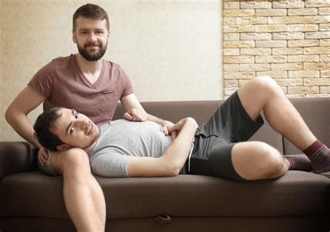 Premium Photo Happy Gay Couple Resting On Sofa At Home